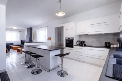 a kitchen with white cabinets and bar stools at Marys House 2 in Rhodes Town