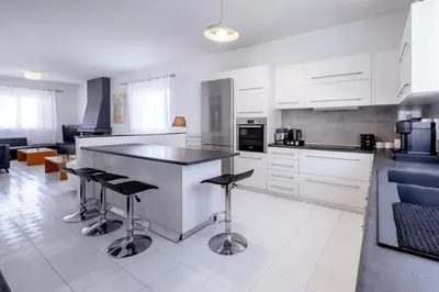 a kitchen with white cabinets and a black counter top at Marys House 2 in Rhodes Town
