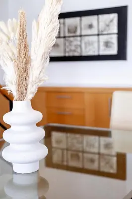 a white vase with feathers in it on a table at Marys House 2 in Rhodes Town