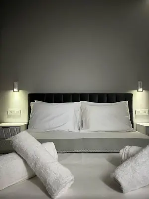 a bedroom with a bed with white sheets and pillows at Castalia Naiades Suites in Ialyssos