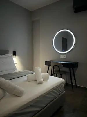 a bedroom with a bed and a mirror on the wall at Castalia Naiades Suites in Ialyssos