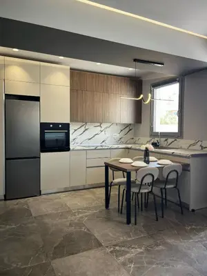 a kitchen with a table and some chairs and a refrigerator at Castalia Naiades Suites in Ialyssos