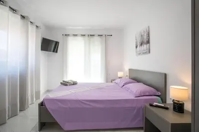 a bedroom with a purple bed and a desk at Aelia House in Kalithies
