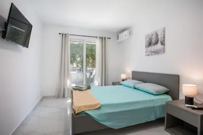 a bedroom with a blue bed and a television at Aelia House in Kalithies