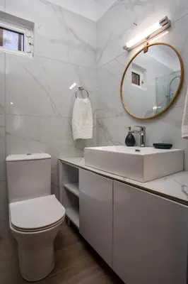 a white bathroom with a sink and a mirror at Aelia House in Kalithies