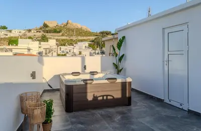 a hot tub on the balcony of a building at Celestial Acropolis View in Archangelos