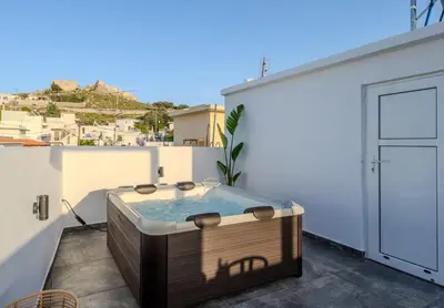 a hot tub on the balcony of a house at Celestial Acropolis View in Archangelos
