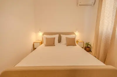 a bedroom with a bed with white sheets and pillows at Celestial Acropolis View in Archangelos