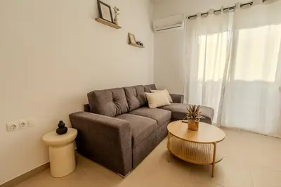 a living room with a couch and a table at Celestial Acropolis View in Archangelos