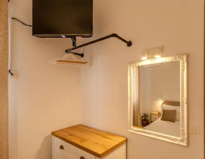 a mirror on a wall next to a room with a bed at Celestial Acropolis View in Archangelos