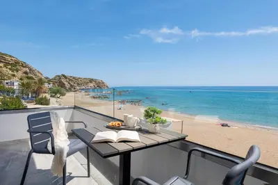 a balcony with a table and a view of the beach at Elysian Luxury Residence in Vrachonisída touArchangélou