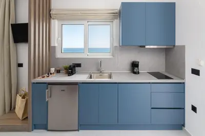 a blue kitchen with a sink and a window at Elysian Luxury Residence in Vrachonisída touArchangélou