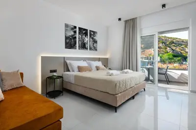 a bedroom with a large bed and a balcony at Elysian Luxury Residence in Vrachonisída touArchangélou