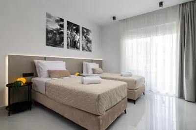 a bedroom with two beds and a large window at Elysian Luxury Residence in Vrachonisída touArchangélou