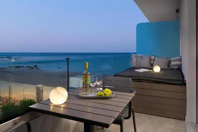 a table with a bottle of wine and grapes on a balcony at Elysian Luxury Residence in Vrachonisída touArchangélou