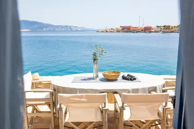 a table with chairs and a view of the water at Villa Annouska in Halki