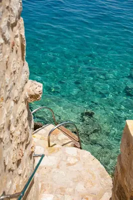 a chair sitting on a rock near the water at Villa Annouska in Halki