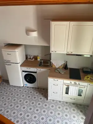 a small kitchen with white cabinets and a sink at NUMĒNIA Seafront Property in Halki