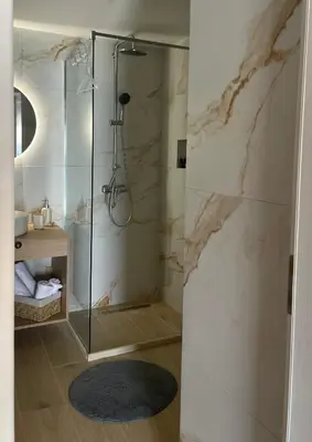 a bathroom with a shower with a glass door at NUMĒNIA Seafront Property in Halki