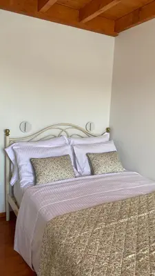 a bedroom with a bed with purple sheets and pillows at NUMĒNIA Seafront Property in Halki