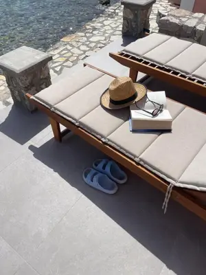 a picnic table with a hat and books and shoes at NUMĒNIA Seafront Property in Halki