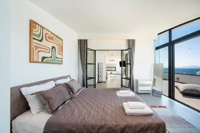 a bedroom with a large bed and a large window at The Gem Loft City Apartment in Rhodes Town