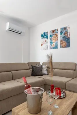 a living room with a couch and a table with wine glasses at Katerina family Apartment in Archangelos