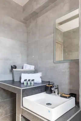 a bathroom with a white sink and a mirror at Katerina family Apartment in Archangelos