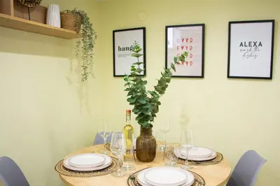 a table with plates and a vase with a plant at The 20A Terminal Stay N Fly in Paradeísion