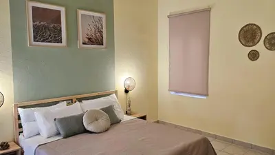 a bedroom with a bed with two lamps and a window at The 20A Terminal Stay N Fly in Paradeísion