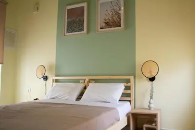 a bedroom with a bed and two mirrors on the wall at The 20A Terminal Stay N Fly in Paradeísion