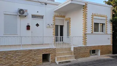 a white house with a balcony and stairs at The 20A Terminal Stay N Fly in Paradeísion