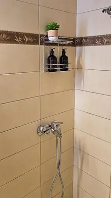 a shower with a faucet and two bottles on a wall at The 20A Terminal Stay N Fly in Paradeísion