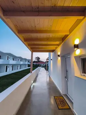 an external view of a building with a wooden ceiling at Zen Beach Suite Faliraki in Faliraki
