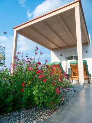 a pavilion with red flowers in a garden at Zen Beach Suite Faliraki in Faliraki