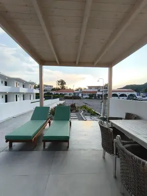 two green benches sitting on top of a patio at Zen Beach Suite Faliraki in Faliraki