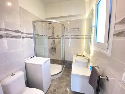 a bathroom with a toilet and a shower and a sink at SimplyCity Homestay Apartment 2 in Kremasti