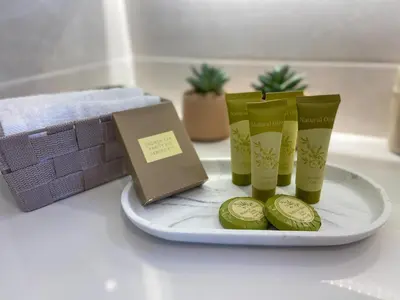 a plate with three green cups and a book at SimplyCity Homestay Apartment 2 in Kremasti