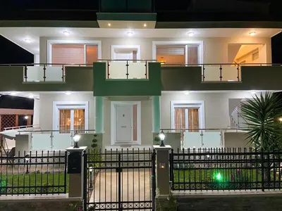 a large white house with a fence in front of it at SimplyCity Homestay Apartment 2 in Kremasti