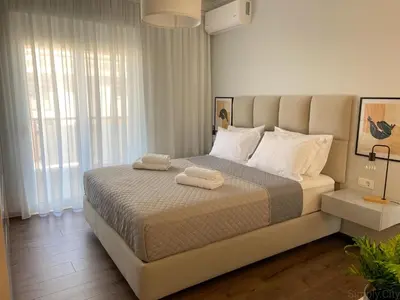 a bedroom with a large bed with two towels on it at SimplyCity Homestay Apartment 2 in Kremasti