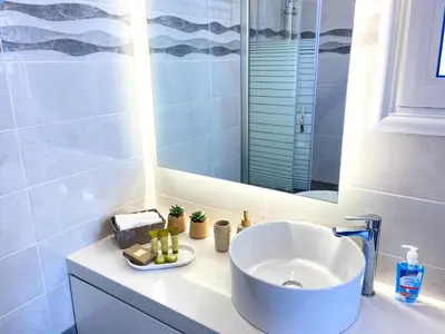 a bathroom with a sink and a mirror at SimplyCity Homestay Apartment 2 in Kremasti
