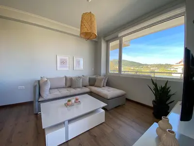 a living room with a couch and a large window at SimplyCity Homestay Apartment 2 in Kremasti