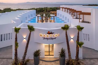 a view of the main building of marlin resort with palm trees at Martini Boutique Resort in Ialyssos