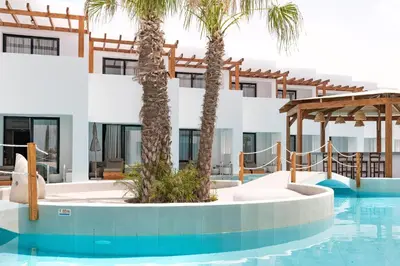 a resort with a swimming pool and palm trees at Martini Boutique Resort in Ialyssos