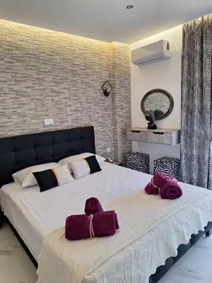a bedroom with a large bed with purple towels on it at EFReMIAS PLACE in Rhodes Town