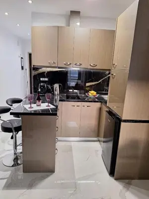 a kitchen with brown cabinets and a black refrigerator at EFReMIAS PLACE in Rhodes Town