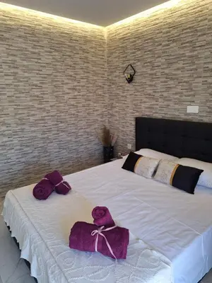 a bedroom with a bed with purple towels on it at EFReMIAS PLACE in Rhodes Town