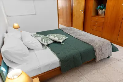 a bed with a green blanket and white pillows at Malona Nostalgia in Malona Village