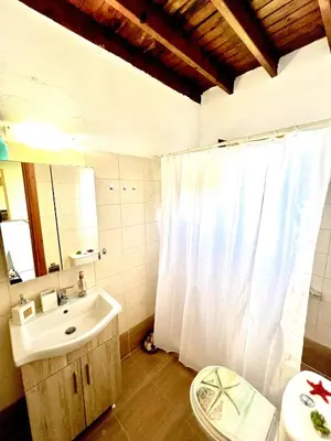 a bathroom with a white shower curtain and a sink at Rafaela suite old town in Rhodes Town