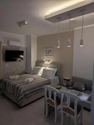 a bedroom with a bed and a table and chairs at Pixel Palace in Rhodes Town